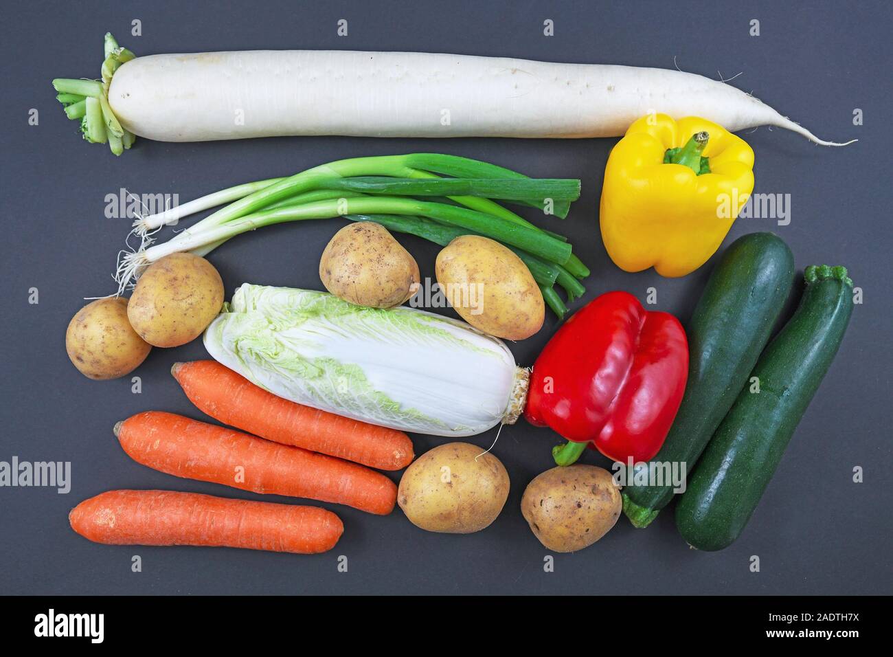 Blick von oben auf die Mischung aus verschiedenen rohes Gemüse wie Frühlingszwiebeln, Kartoffeln, Möhren, Paprika und Zucchini Stockfoto