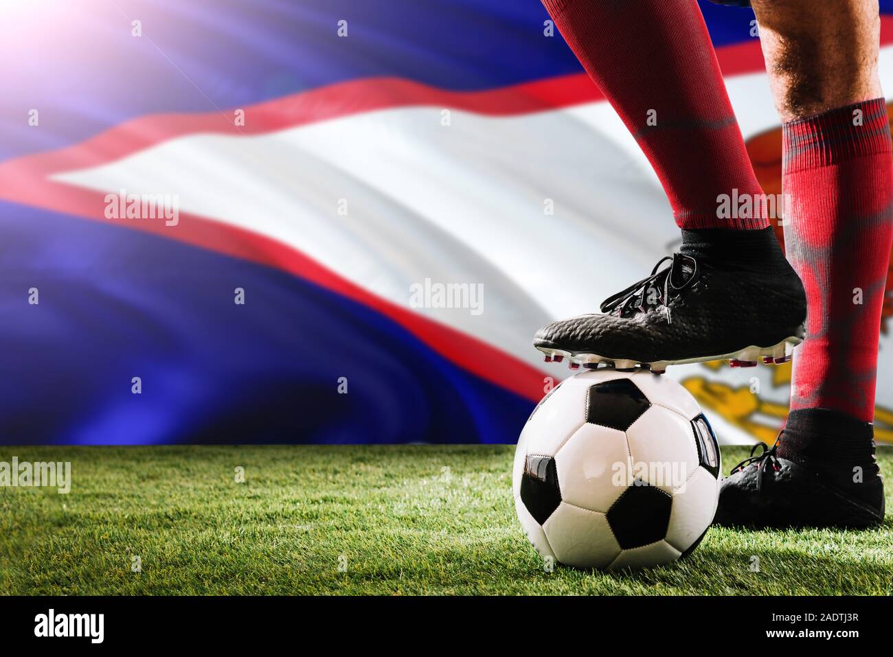 Nahaufnahme Beine von Amerikanisch-samoa Fußballmannschaft Spieler in roten Socken, Schuhe auf Fußball im Free Kick oder elfmeterpunkt Spielen auf Gras. Stockfoto