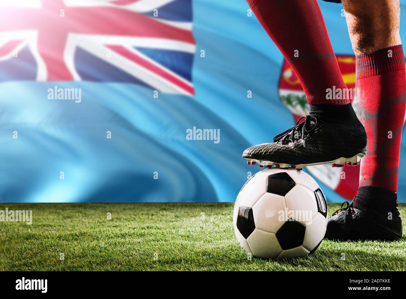 Nahaufnahme Beine von Fidschi Fußballmannschaft Spieler in roten Socken, Schuhe auf Fußball im Free Kick oder elfmeterpunkt Spielen auf Gras. Stockfoto