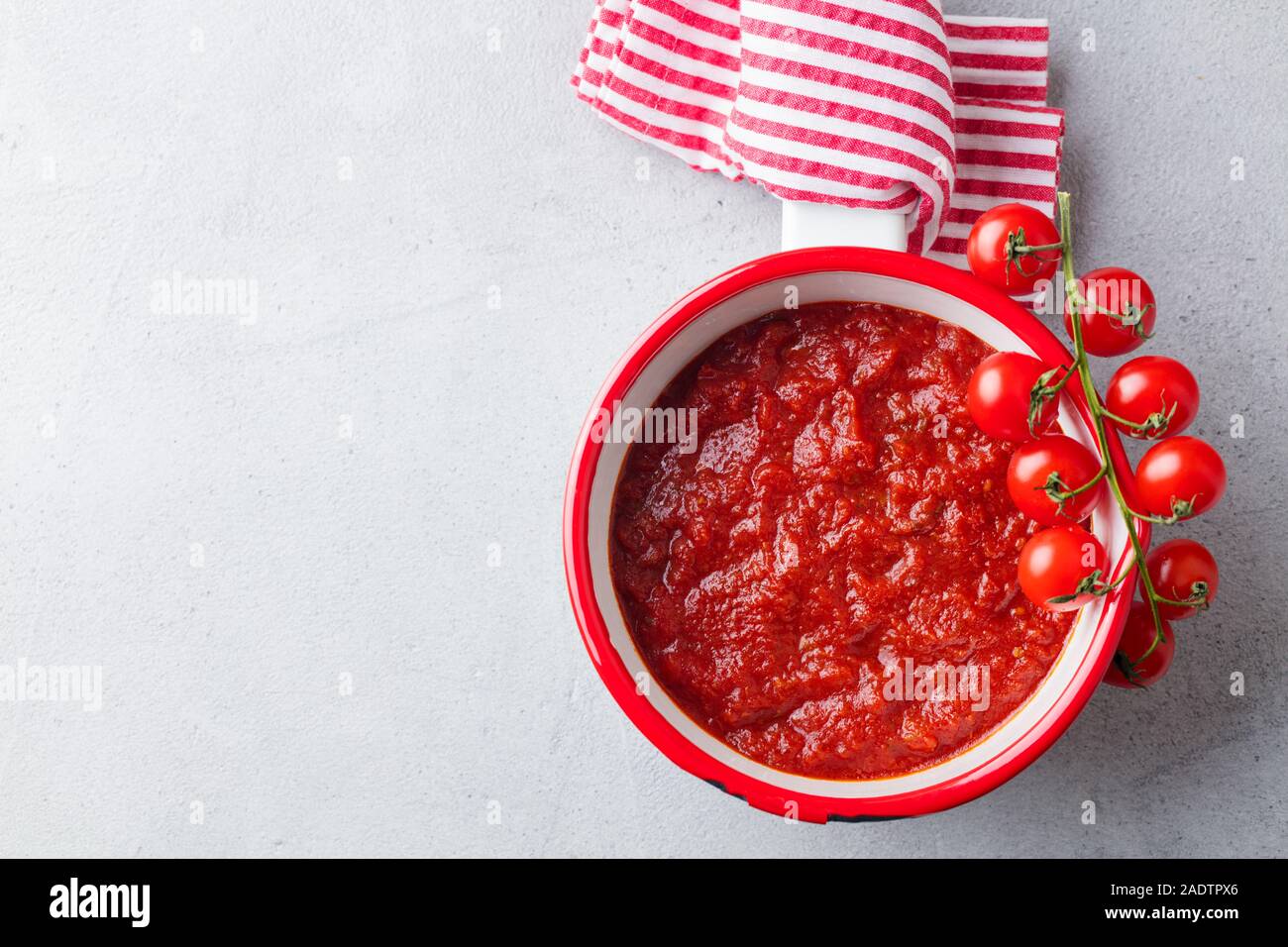Traditionelle Tomatensauce in Kochtopf. Grauer Hintergrund. Ansicht von oben. Platz kopieren Stockfoto