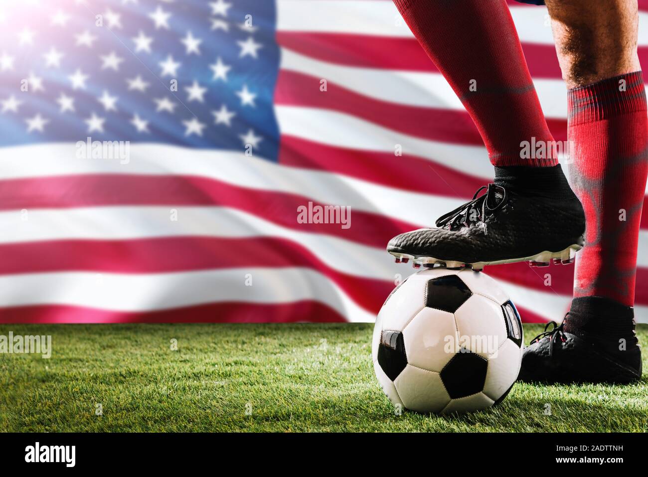 Nahaufnahme Beine von United States Football Team Player in roten Socken, Schuhe auf Fußball im Free Kick oder elfmeterpunkt Spielen auf Gras. Stockfoto