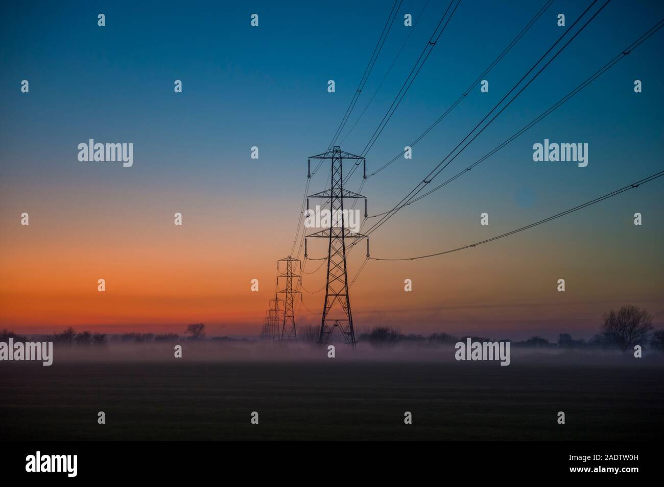 Strommasten bei Sonnenuntergang auf der Somerset Levels Neil Phillips Foto und Film Dec 4 2019 Stockfoto