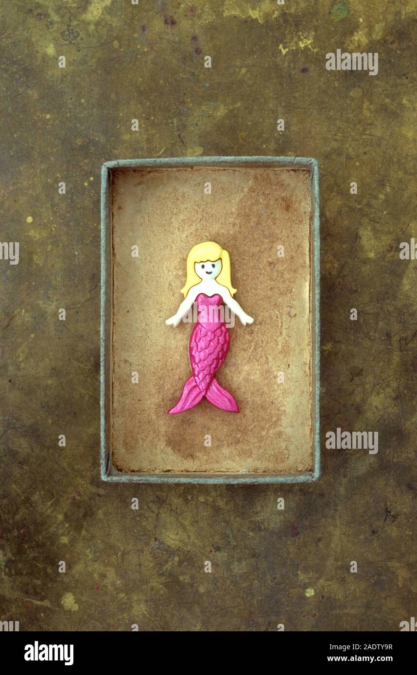 Modell der Meerjungfrau mit rosa Körper und blonde Haare liegen in kleinen bunten Karton Stockfoto