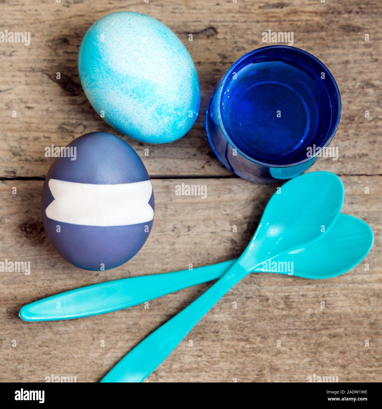 Blaue Ostereier, Eier Farbstoffe und ein Löffel auf Holztisch, flatlay mit Copyspace Stockfoto