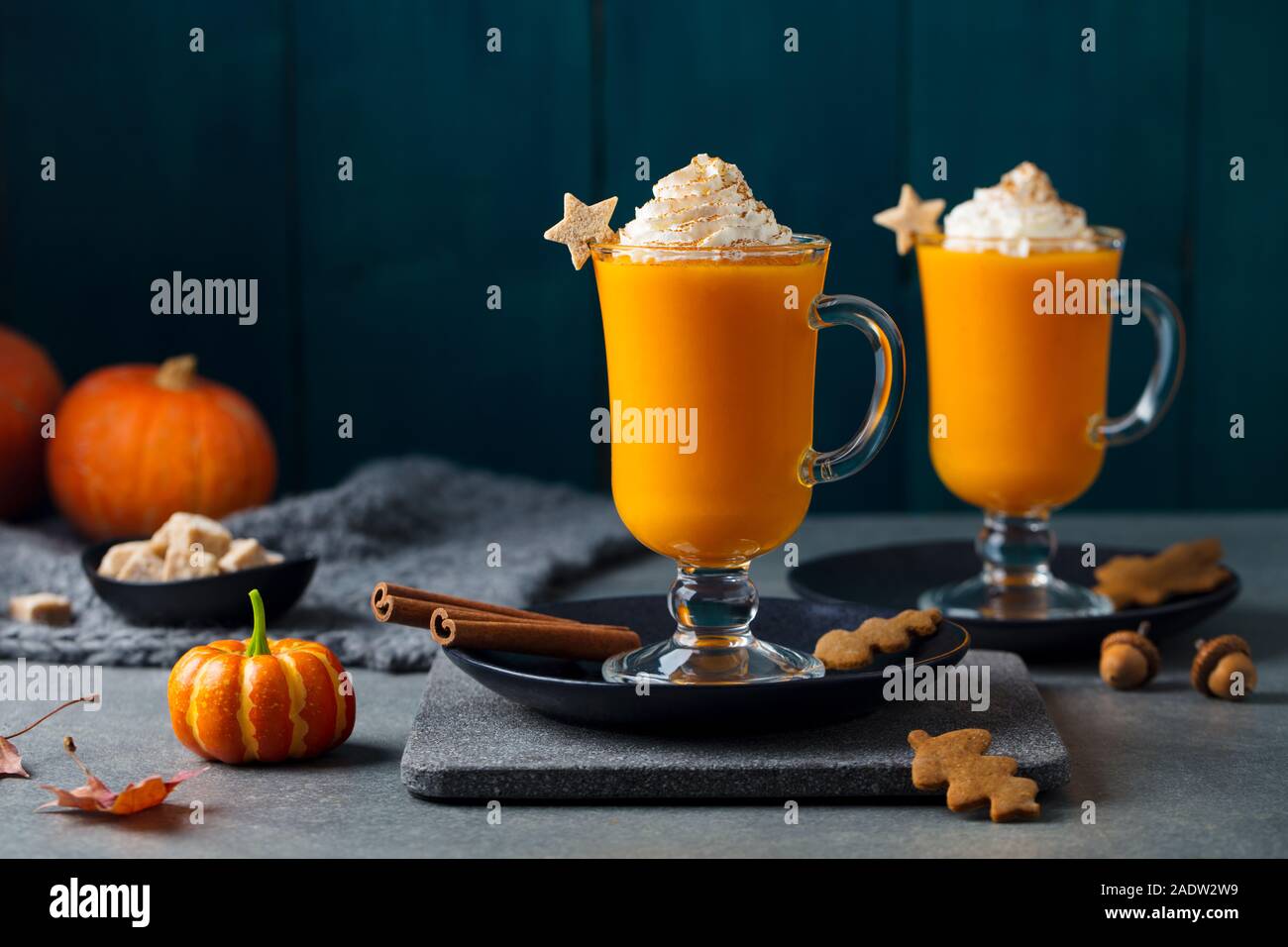 Kürbis Latte mit Gewürzen. Versoffenes Cocktail mit Schlagsahne auf Schiefer. Grauer Hintergrund. Platz kopieren Stockfoto