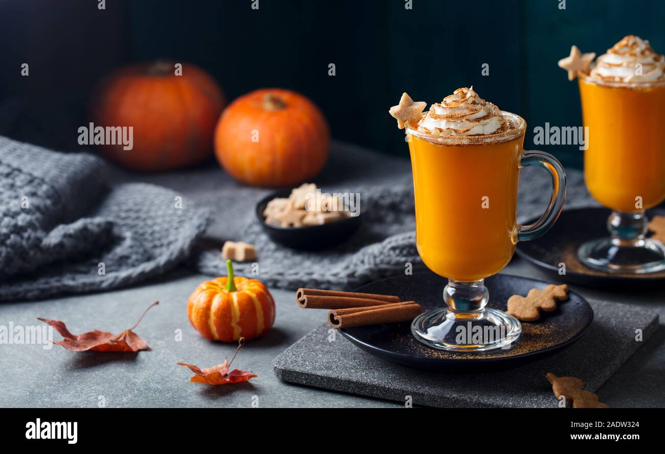 Kürbis Latte mit Gewürzen. Versoffenes Cocktail mit Schlagsahne auf Schiefer. Grauer Hintergrund. Platz kopieren Stockfoto