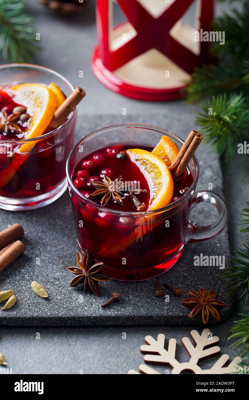 Glühwein Rotwein mit Gewürzen. Weihnachtsdekoration. Grauen Stein Hintergrund Stockfoto