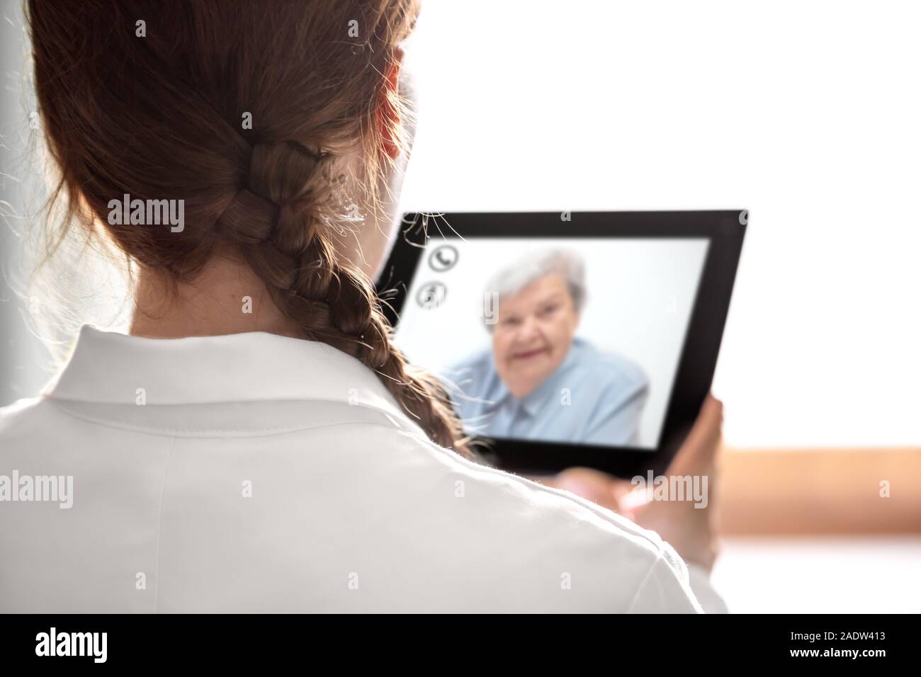 Der Arzt Rücksprache mit Telemedizin oder Telehealth, ältere Frau auf dem Display eine Tablette, Copyspace Stockfoto