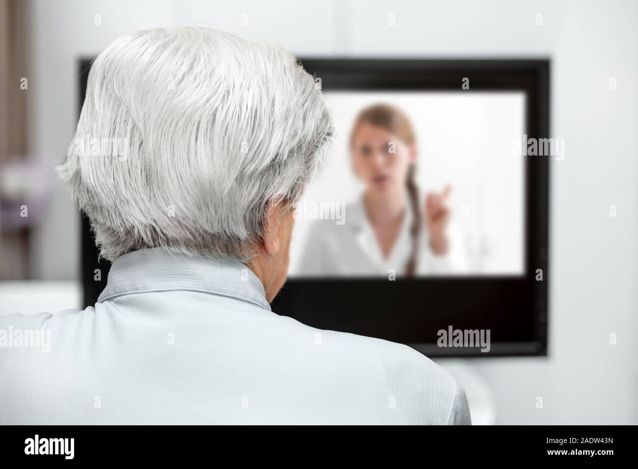 In-home Care für einen älteren Patienten mit Telemedizin oder Telehealth, virtuelle Live Chat auf dem Monitor Stockfoto