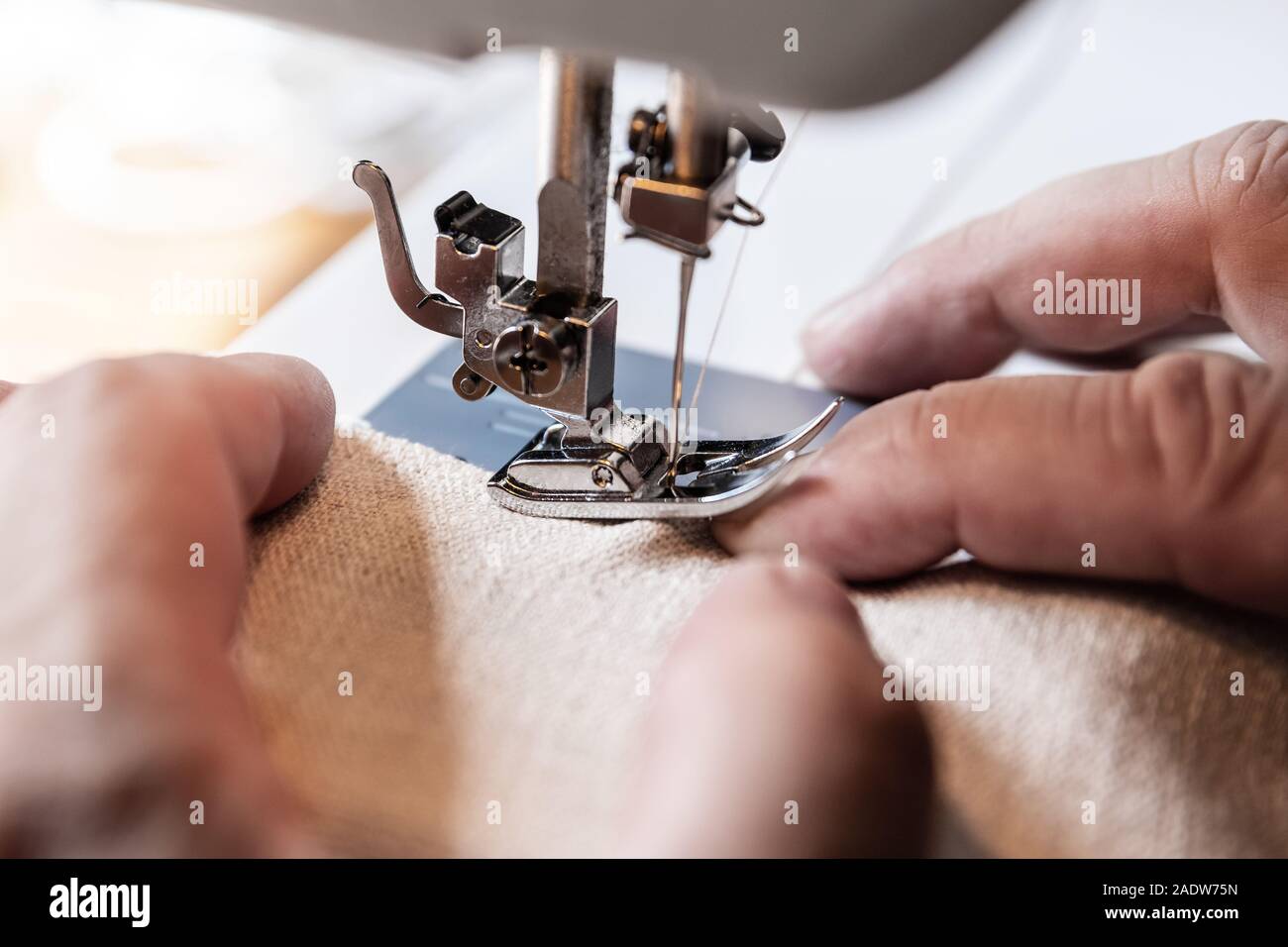 Der Mensch ist mit einem bösen Unfall mit einer Nähmaschine, Nähen mit der Nadel in den Finger Stockfoto