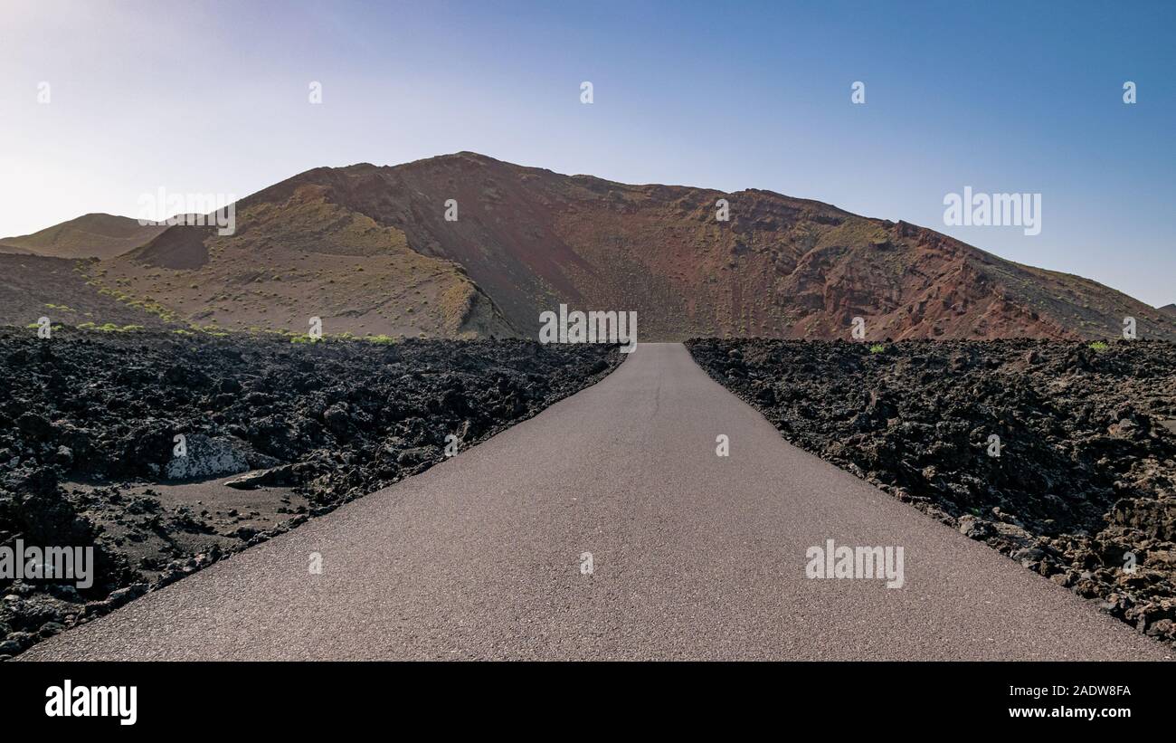 Gerade asphaltierte Straße von vulkanischen Insel Lanzarote, Kanarische Inseln, Spanien. Stockfoto