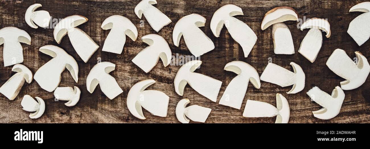 Frische Scheiben von Steinpilzen oder Boletus edulis auf braunem Holz Boden, Topview Banner Stockfoto
