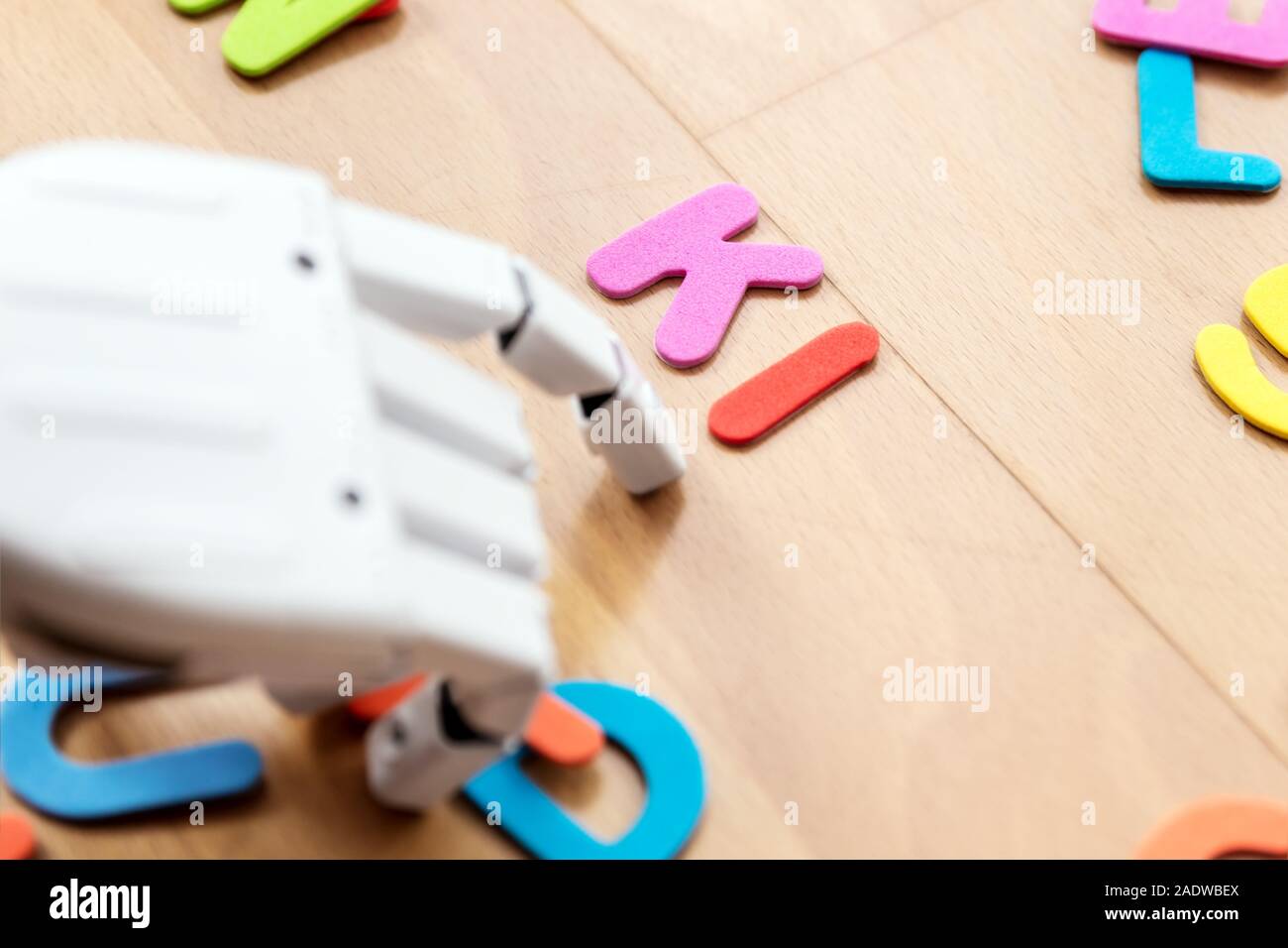 Roboterhand und bunte Buchstaben mit dem Wort Ki Stockfoto