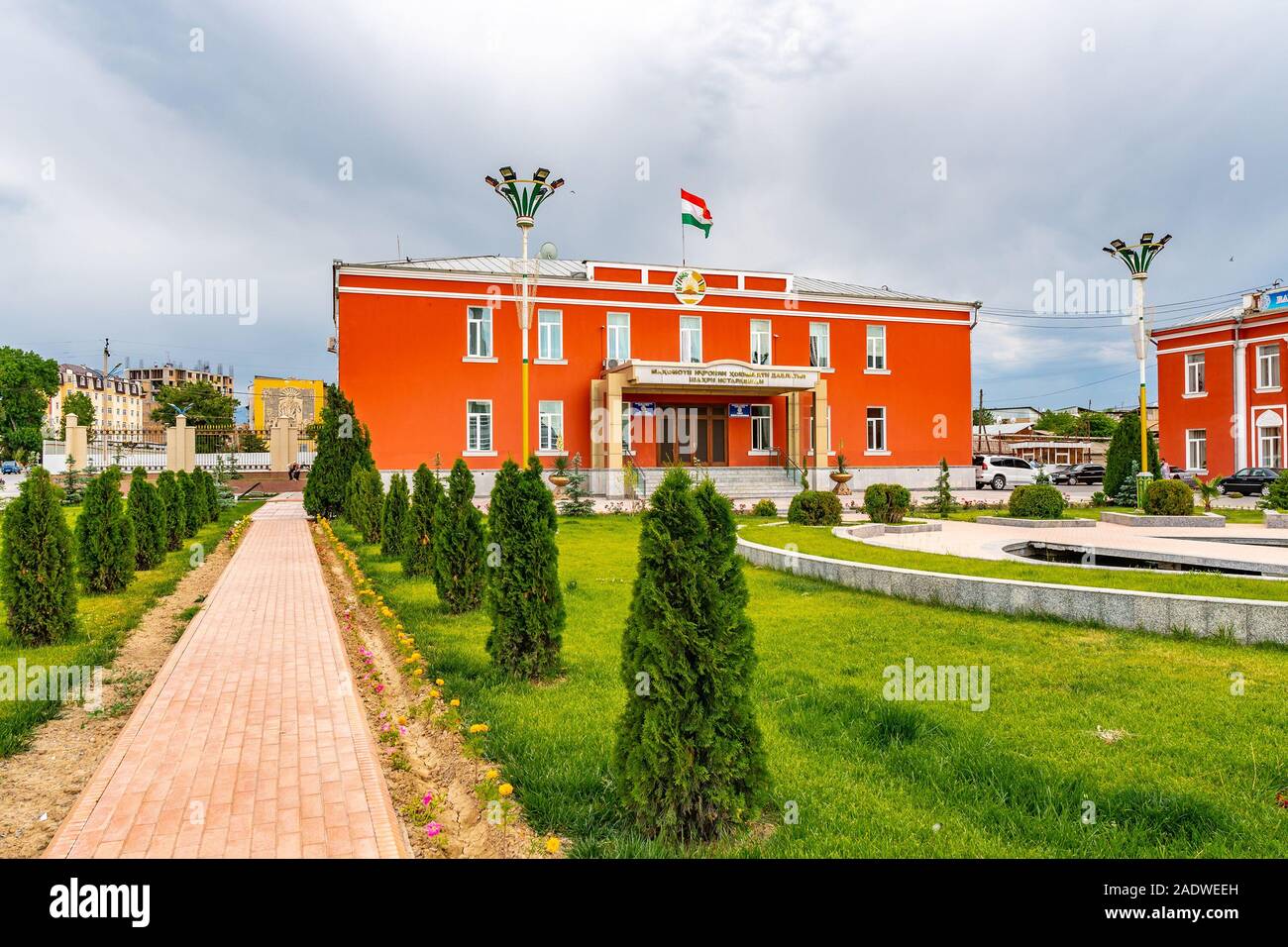 Istaravshan malerischen Blick auf die Stadt Verwaltungsgebäude mit Winkenden Tadschikistan Flags an einem bewölkten Tag Stockfoto