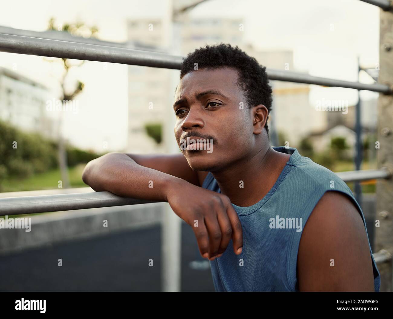 Close-up Portrait von nachdenklich afrikanischen amerikanischen Jungen Mann stützte sich auf eine Bar im Fitnessstudio Park Stockfoto