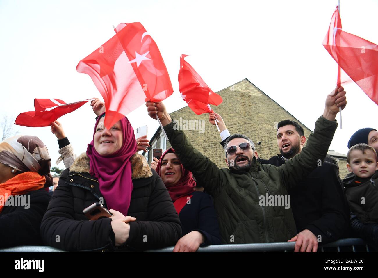 Mitglieder der öffentlichkeit wave Flags als Präsident der Türkei, Recep Tayyip Erdogan, trifft mit der wagenkolonne die offizielle Eröffnung des neuen Cambridge Central Moschee teilzunehmen, in Cambridge. Stockfoto