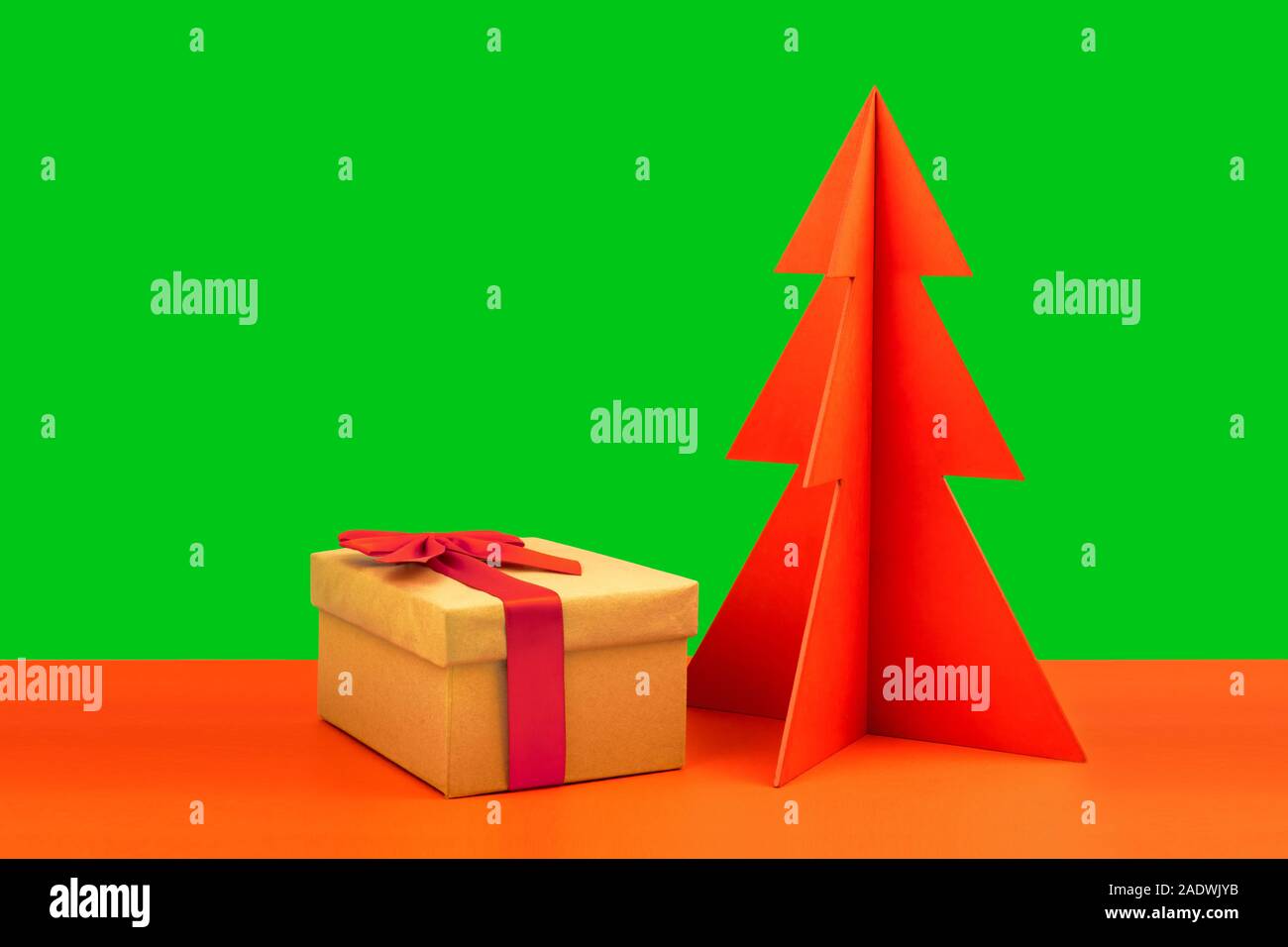 Geschenkbox und Umschlag mit rotem Holz Weihnachtsbaum auf einem natürlichen braunen Hintergrund mit verstreuten Herzen. Stockfoto