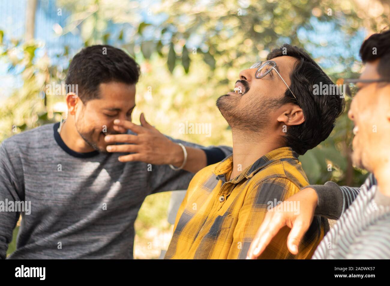 Drei junge Erwachsene lachen und Spaß an der Picknick - Konzept der glücklichen Freundschaft - jugendliche männliche Freunde Geselligkeit an der Hochschule. Stockfoto