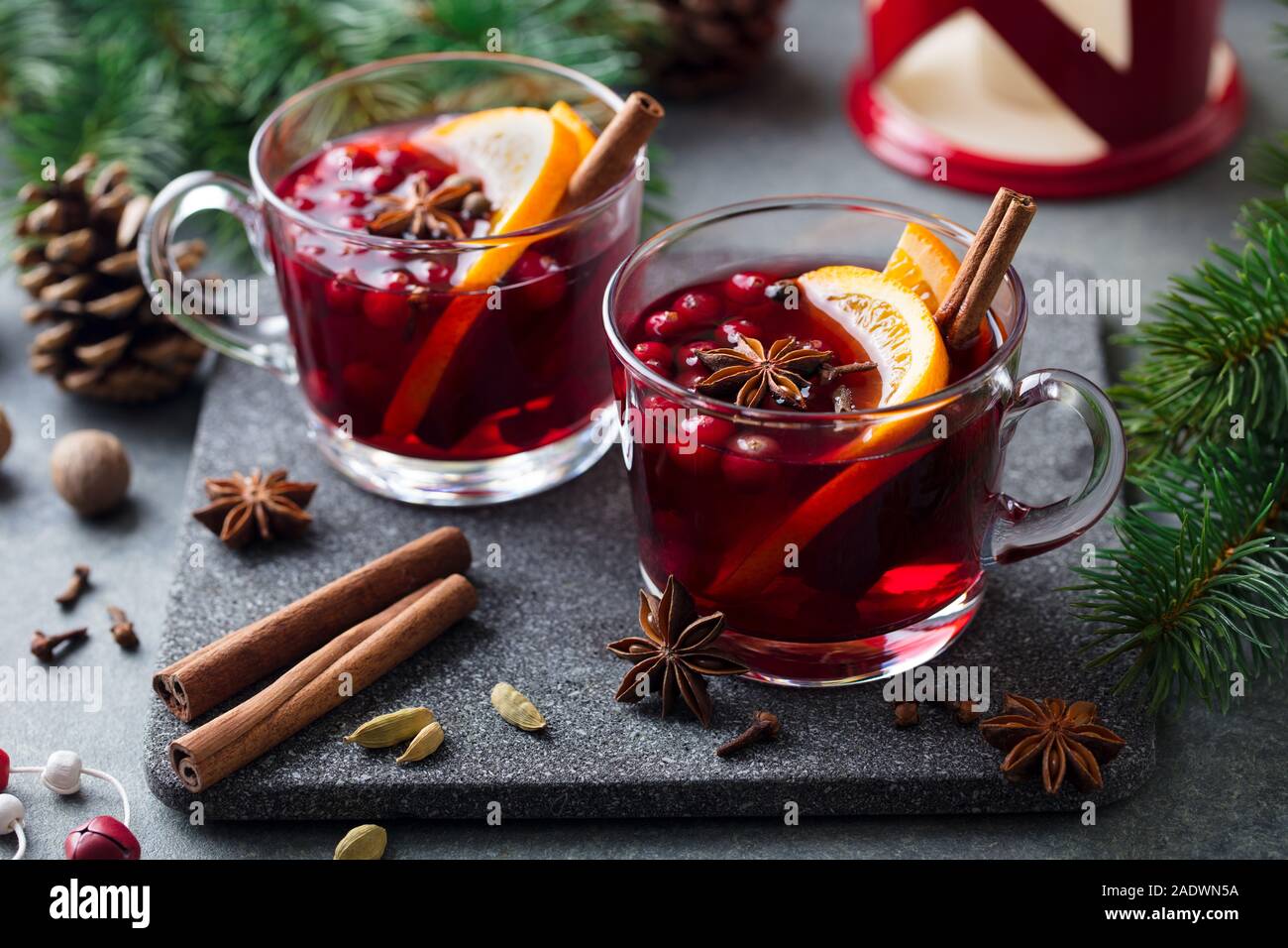 Glühwein Rotwein mit Gewürzen. Weihnachtsdekoration. Grauer Hintergrund. Nahaufnahme Stockfoto