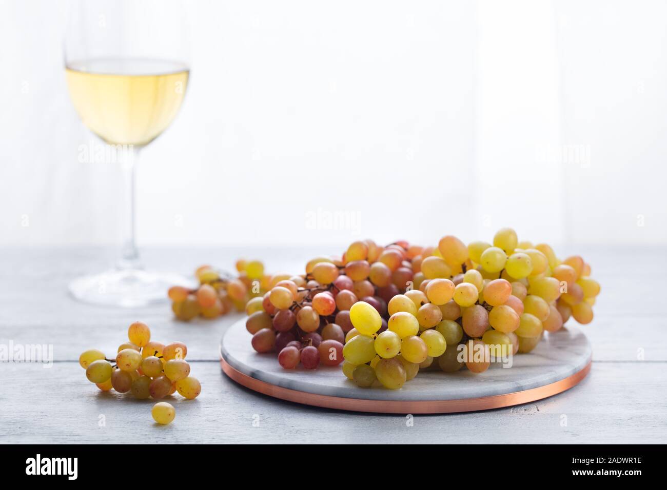 Aus frischen Weintrauben auf Marmor Schneidbrett mit Gläsern Weißwein. Holz- Hintergrund. Platz kopieren Stockfoto