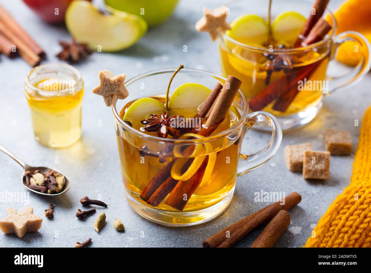 Apple Glühwein Apfelwein mit Gewürzen in Glas Schale. Grauer Hintergrund. Nahaufnahme Stockfoto