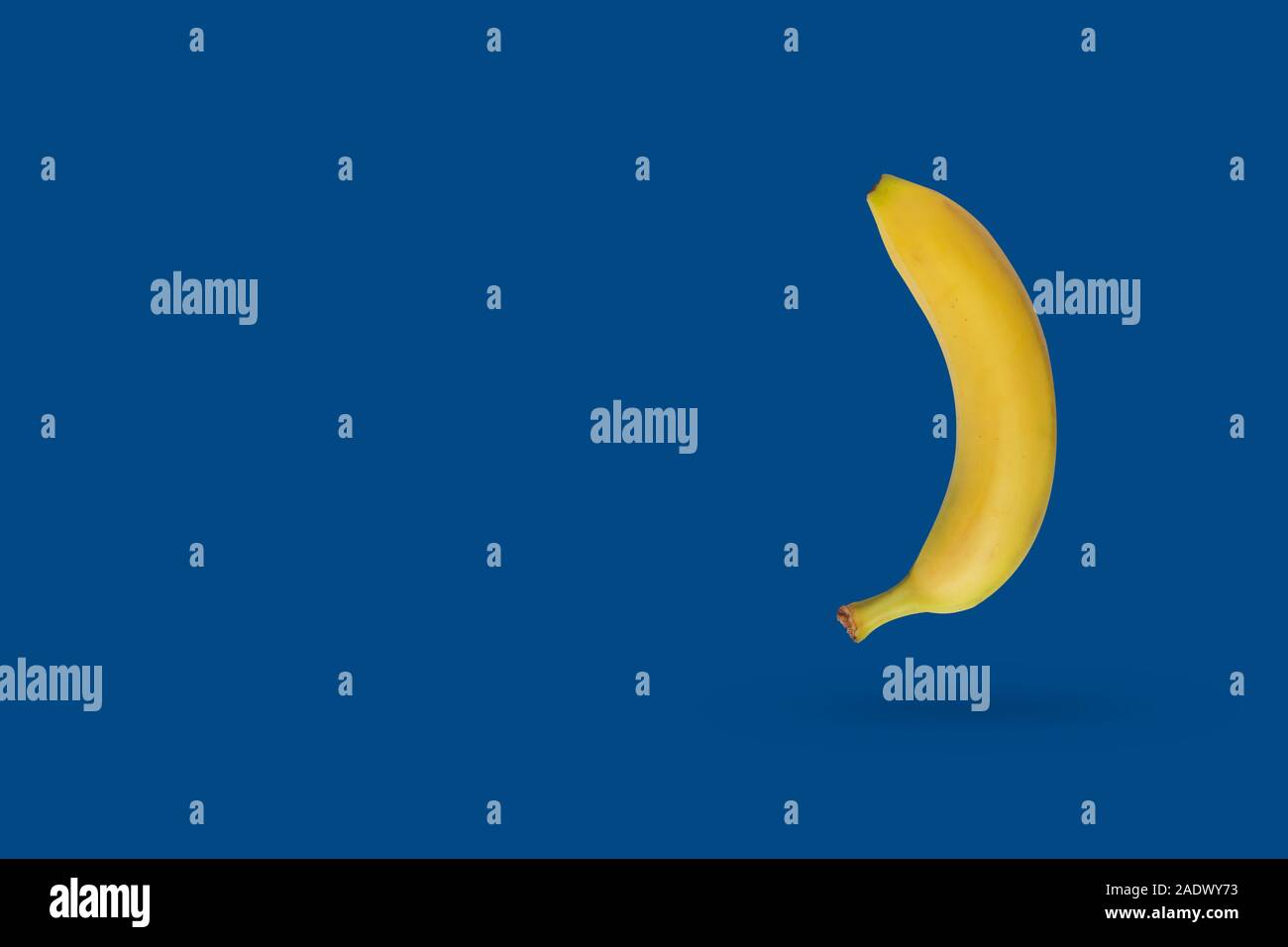 Gelbe Banane auf einem blauen Hintergrund mit kopieren. Klassische Farbkombination für 2020 Stockfoto