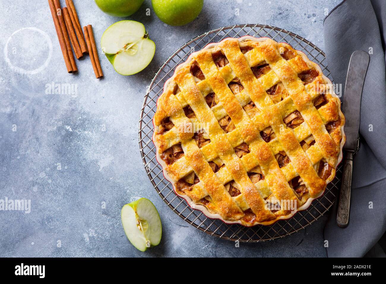 Apfelkuchen mit Karamellsauce auf einem Gitter. Grauer Hintergrund. Kopieren Sie Platz. Ansicht von oben Stockfoto