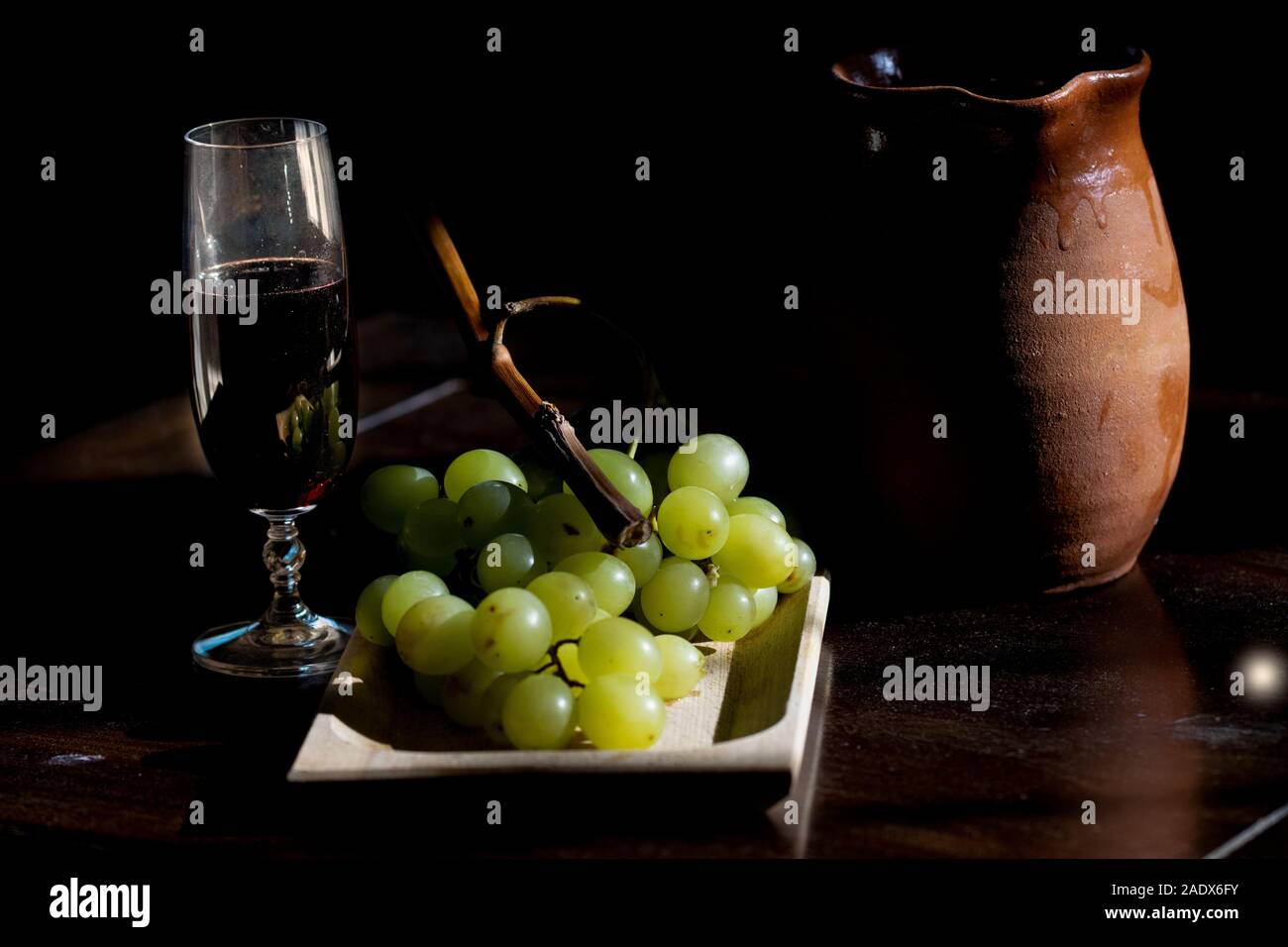 Konzept der havest mit einer Weintraube in Licht und Schatten Stockfoto