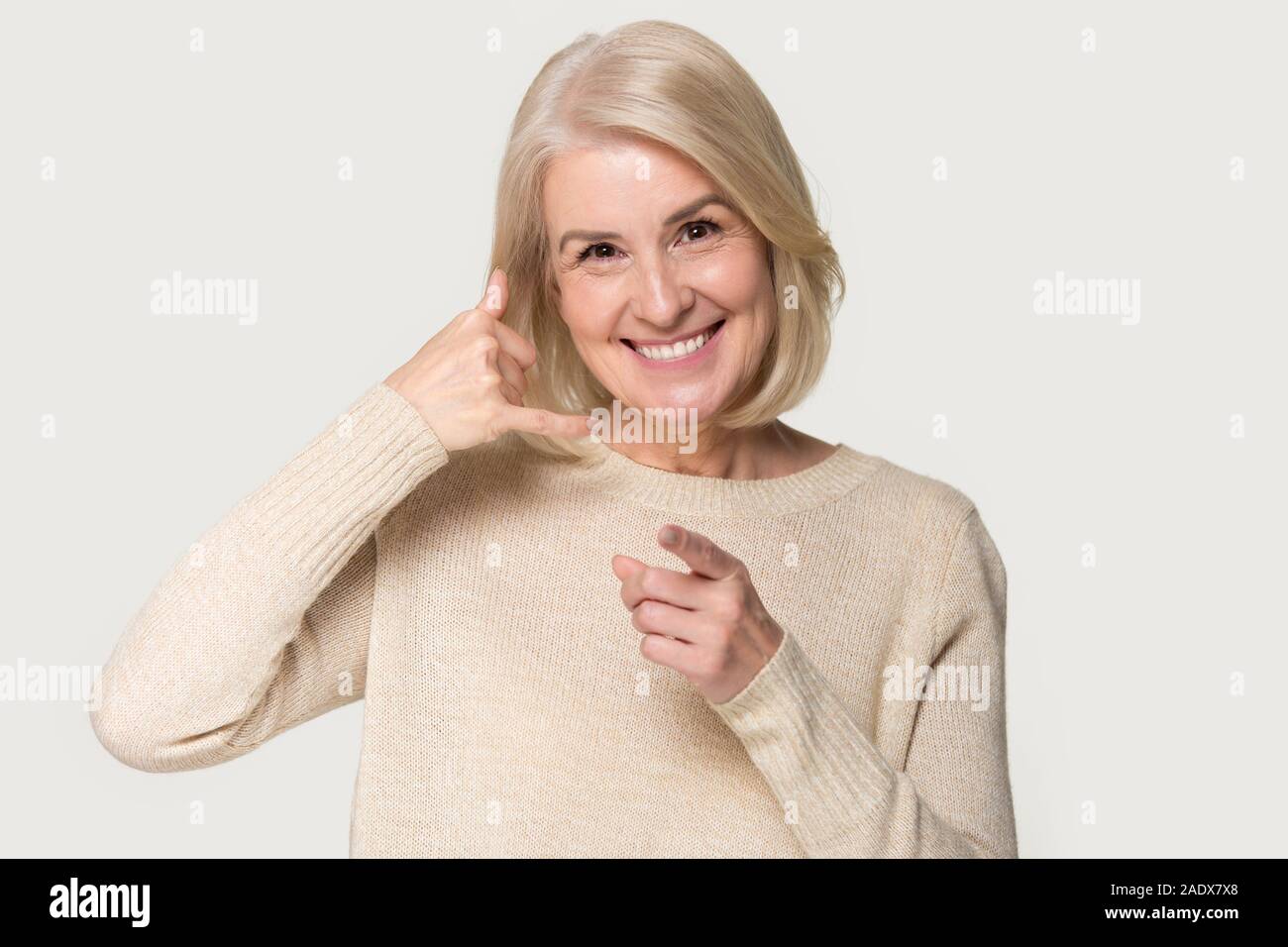 Alte Frau, call back Zeichen auf grauem Hintergrund Stockfoto