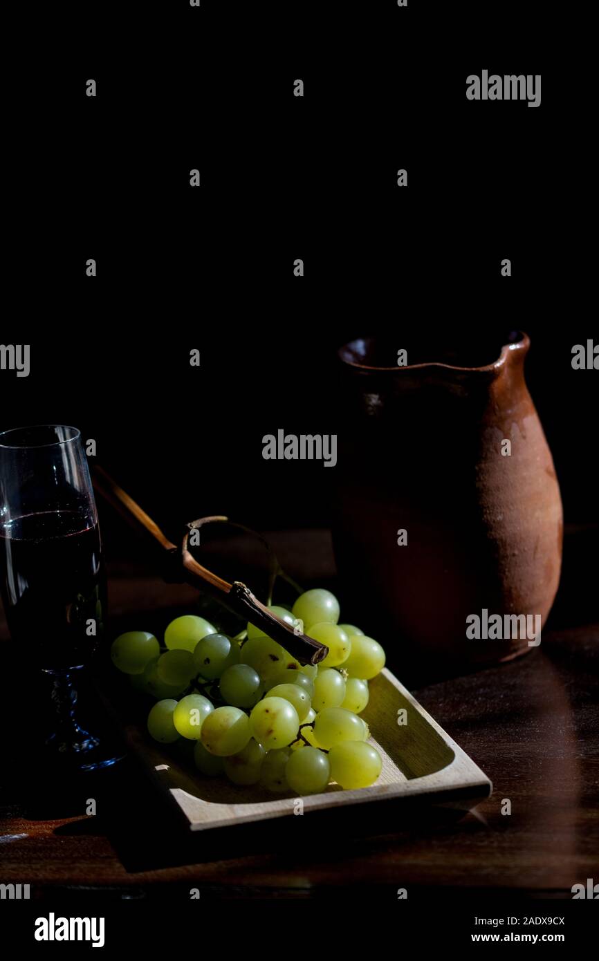 Konzept der havest mit einer Weintraube in Licht und Schatten Stockfoto