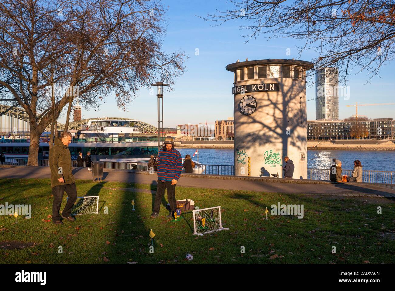 Der Wasserstand am Rhein, Blick auf das Dreieck Turm im Stadtteil Deutz, Männer spielen kicket Fußball, Köln, Deutschland. Pegeluhr ein Stockfoto