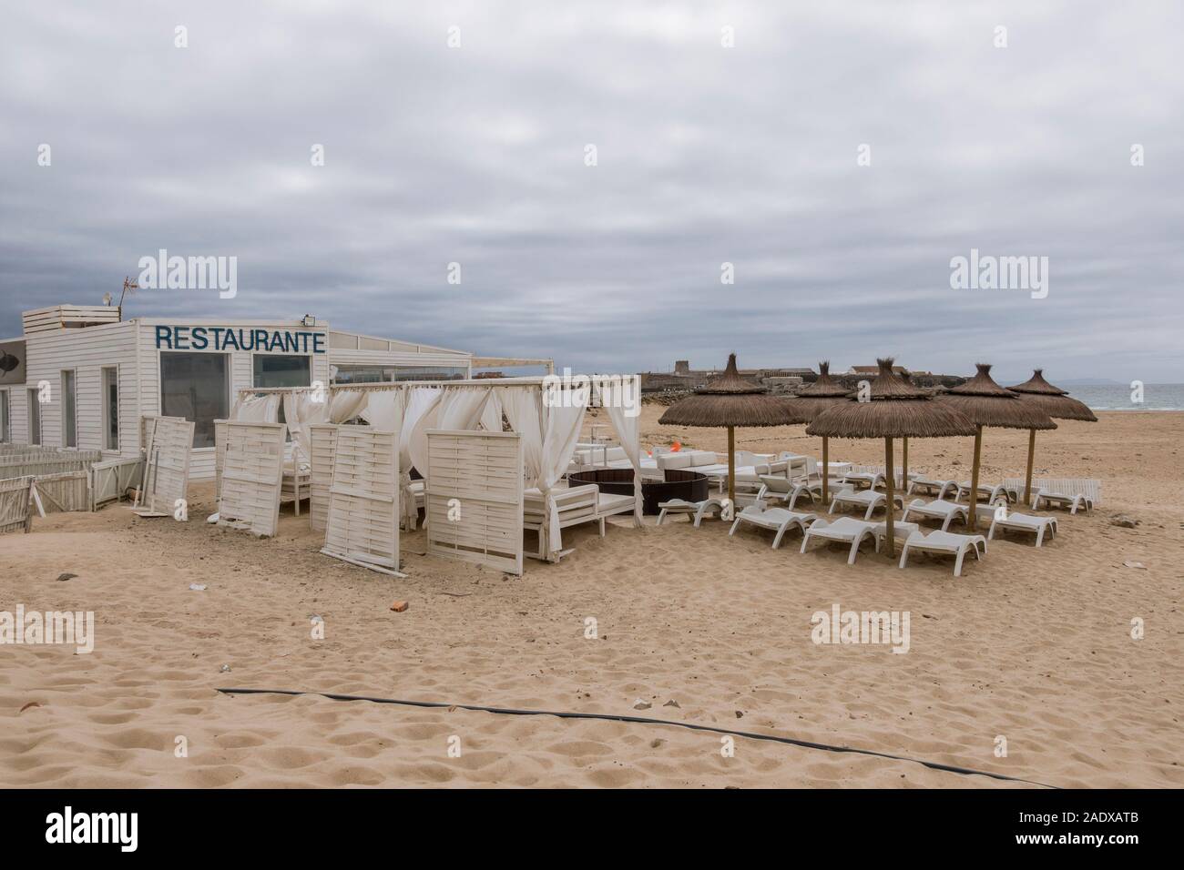 Geschlossene, leere Strandbar, zwinguito mit Sonnenschirmen an einem trüben Tag, Andalusien, Spanien, Europa. Stockfoto