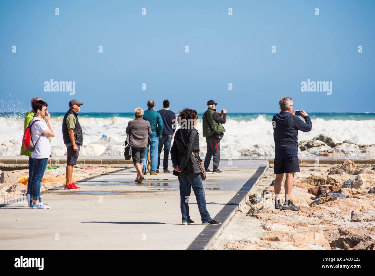 Leute beobachten, die hohe Wellen, Gezeiten und Wind am Pier, Fuengirola, Malaga, Andalusien. Spanien Stockfoto