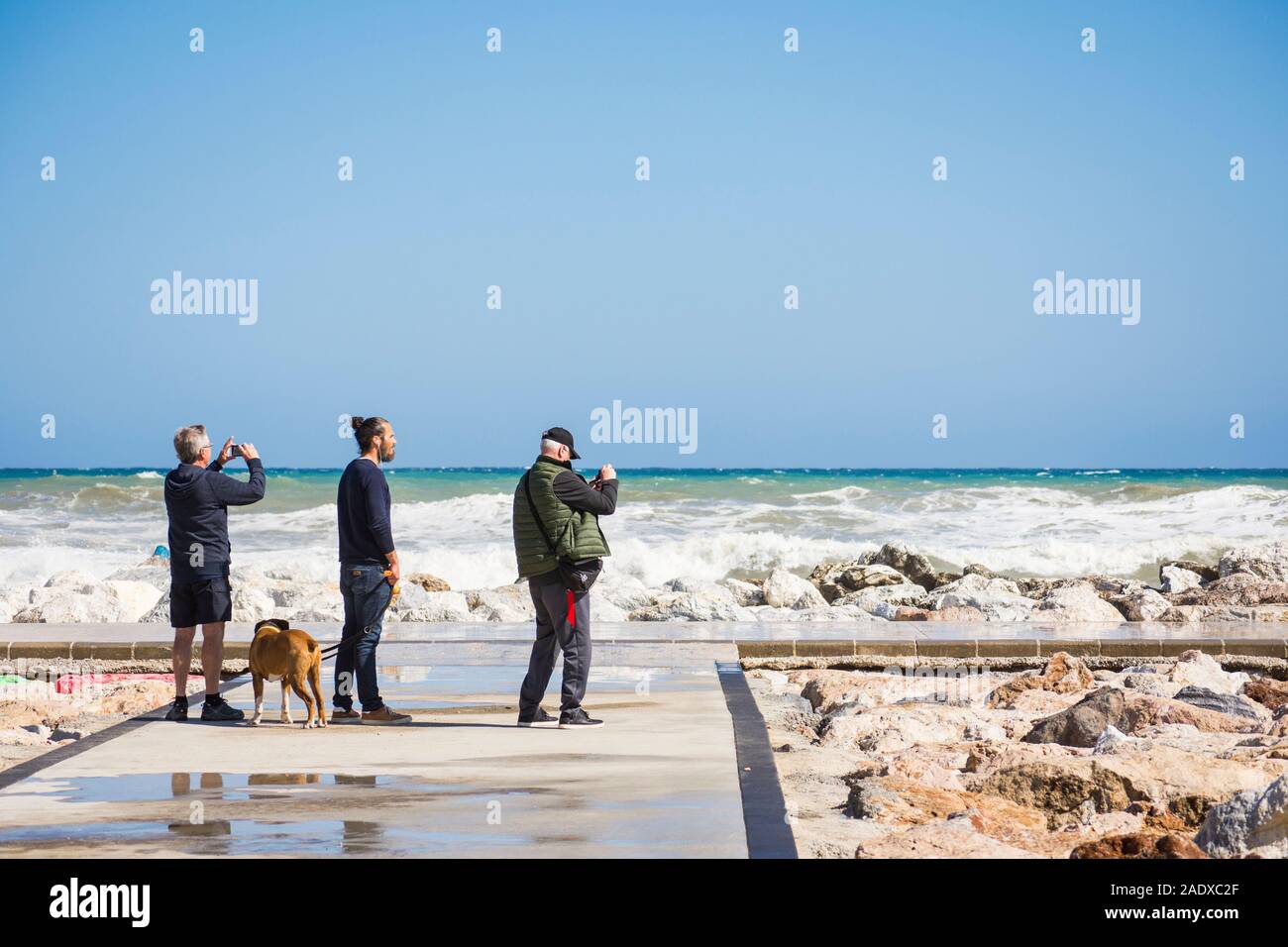 Leute beobachten, die hohe Wellen, Gezeiten und Wind am Pier, Fuengirola, Malaga, Andalusien. Spanien Stockfoto