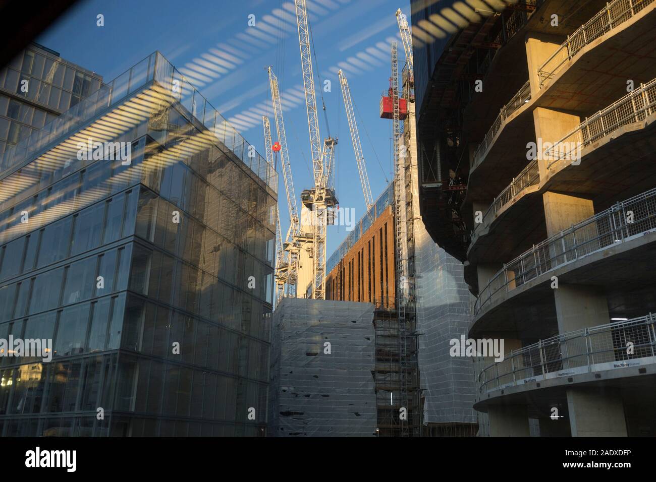 Aus dem Fenster eines Zuges Kutsche, die in Richtung Victoria Station Reisen gesehen wird, ist eine Landschaft von Kränen und Galgen an der großen Battersea Power Station Baustelle, in London, England, am 4. Dezember 2019. Stockfoto