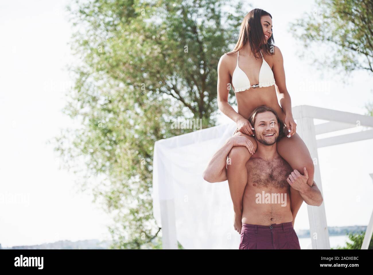 Glückliche junge Mann seine Frau das Tragen auf den Schultern der Strand Stockfoto