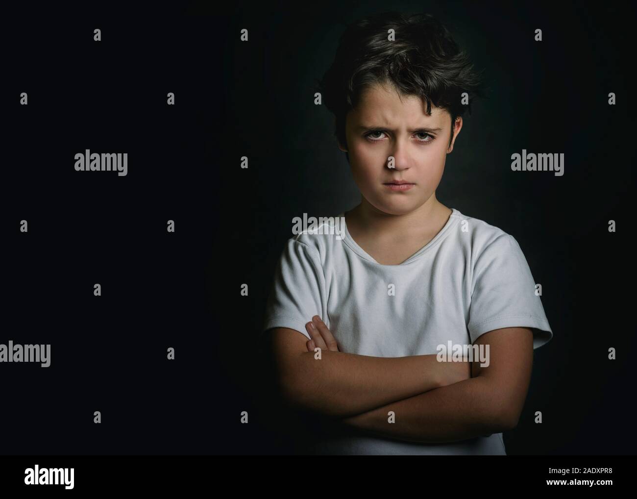 Wütend Kind auf schwarzem Hintergrund Stockfoto