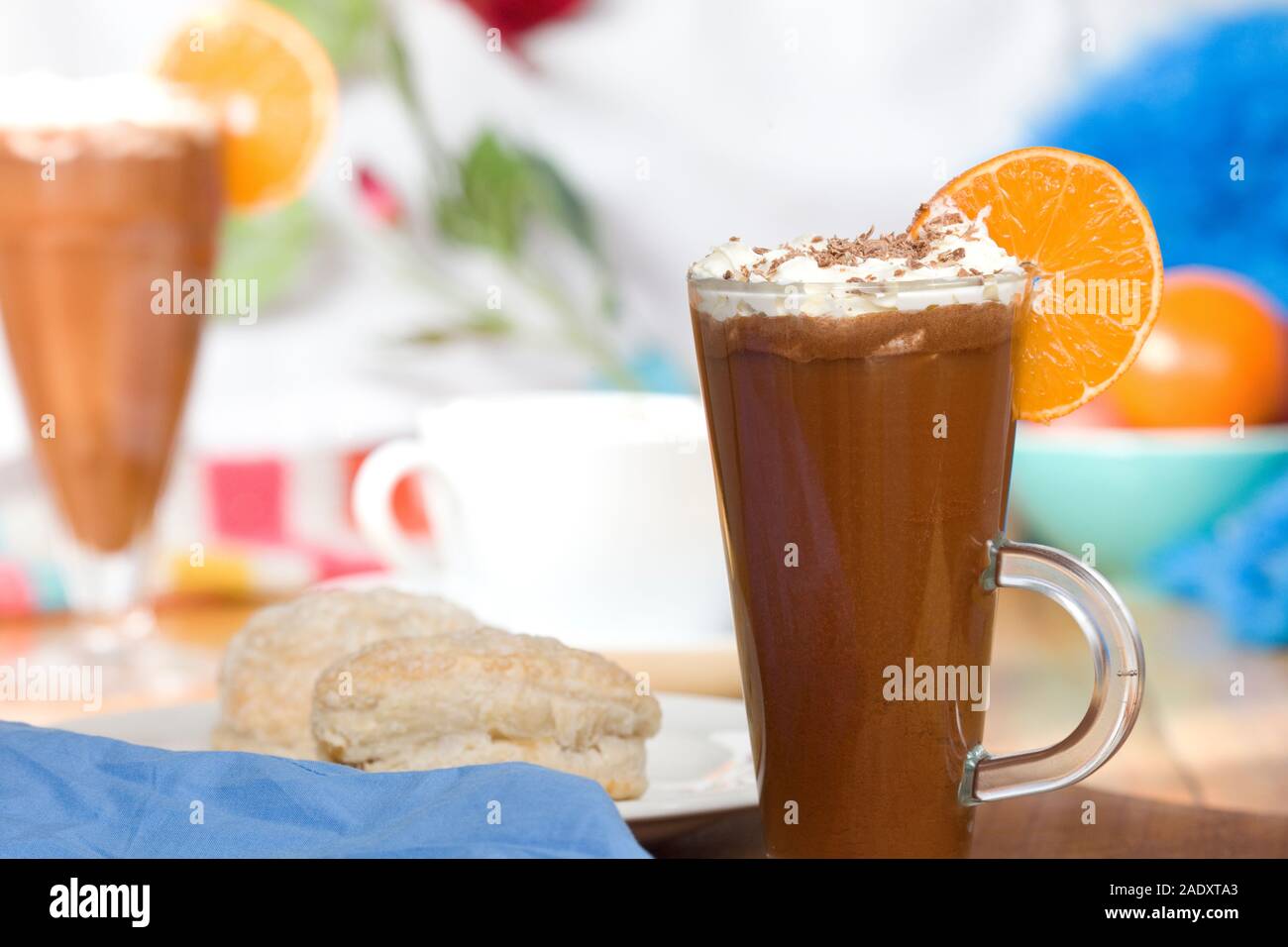 Heiße Schokolade trinken im hohen Glas mit Orange Slice und Rahm Stockfoto