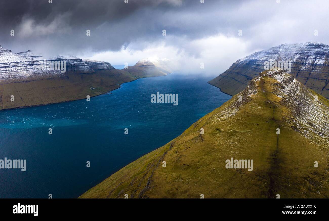 Luftaufnahme der Insel Kalsoy und dem Klakkur Berg in der Nähe der Stadt von klaksvik auf den Färöer Inseln mit dramatischen Wolken. Stockfoto