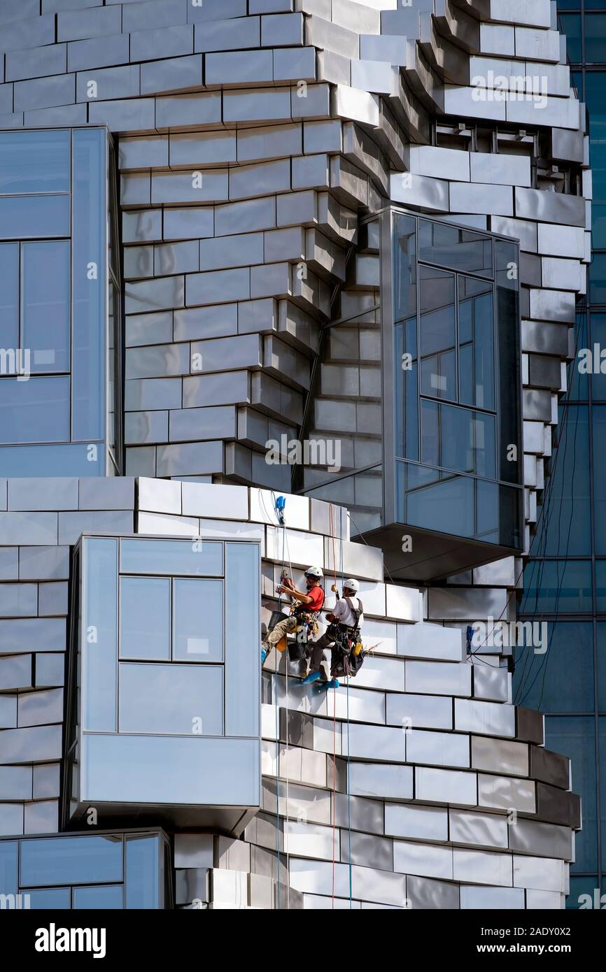 Zwei Arbeiter hängend Abseilen/Abseilen während der Reinigung Platten auf Frank Gehry LUMA Foundation Gebäude, Luma kulturelles Zentrum von Arles, Arles, Frankreich Stockfoto