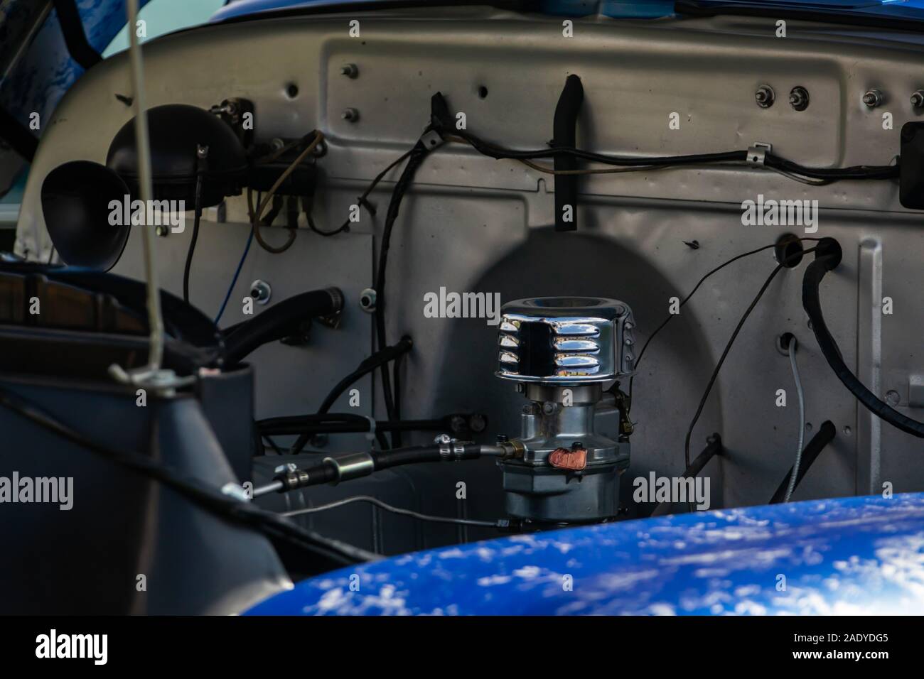 Alte Klassiker unter der Motorhaube, Aussicht aus verchromtem Vergaser und Rohre, Drähte, Rohre, mechanische und elektrische andere Teile des Motors Stockfoto