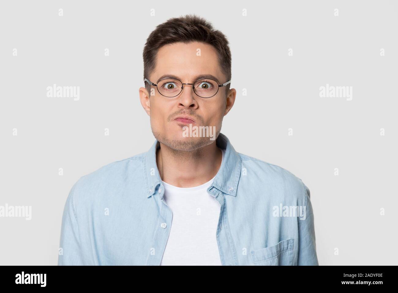 Headshot von verwirrt wütenden Mann in Brillen bei Camera suchen Stockfoto