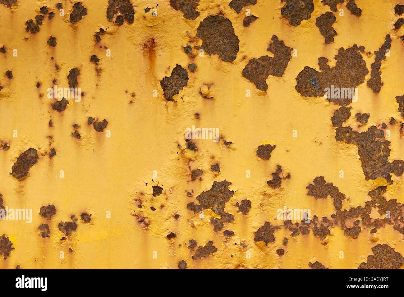 Close-up von Verwitterten gelb lackierte Oberfläche aus Metall mit großen und kleinen Roststellen. Stockfoto