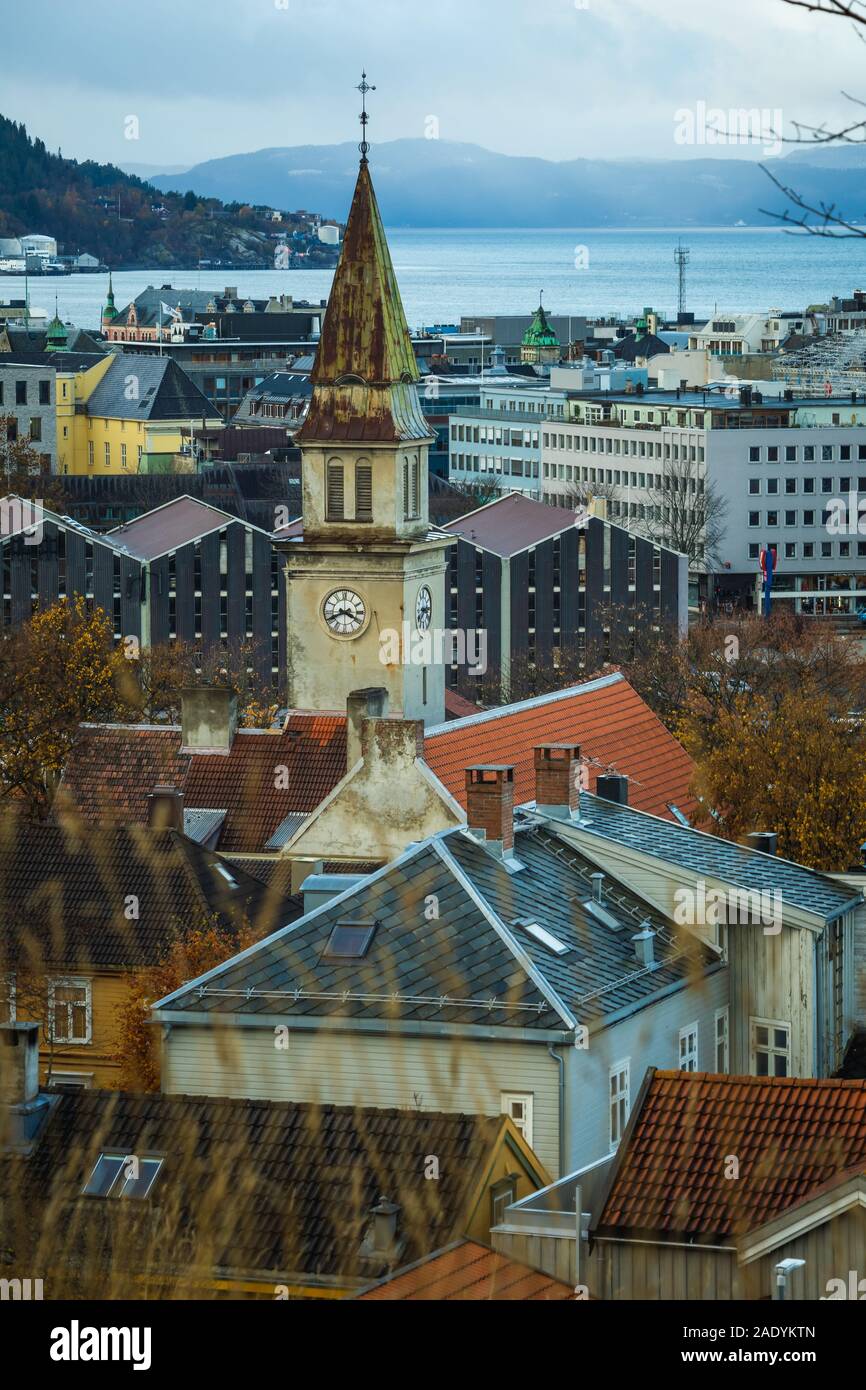 Alte und hohe uhrturm oben Stadt Häuser und Dächer in der industriellen Teil der Stadt Trondheim in Norwegen. Herbstliche Wetter und Farben. Stockfoto