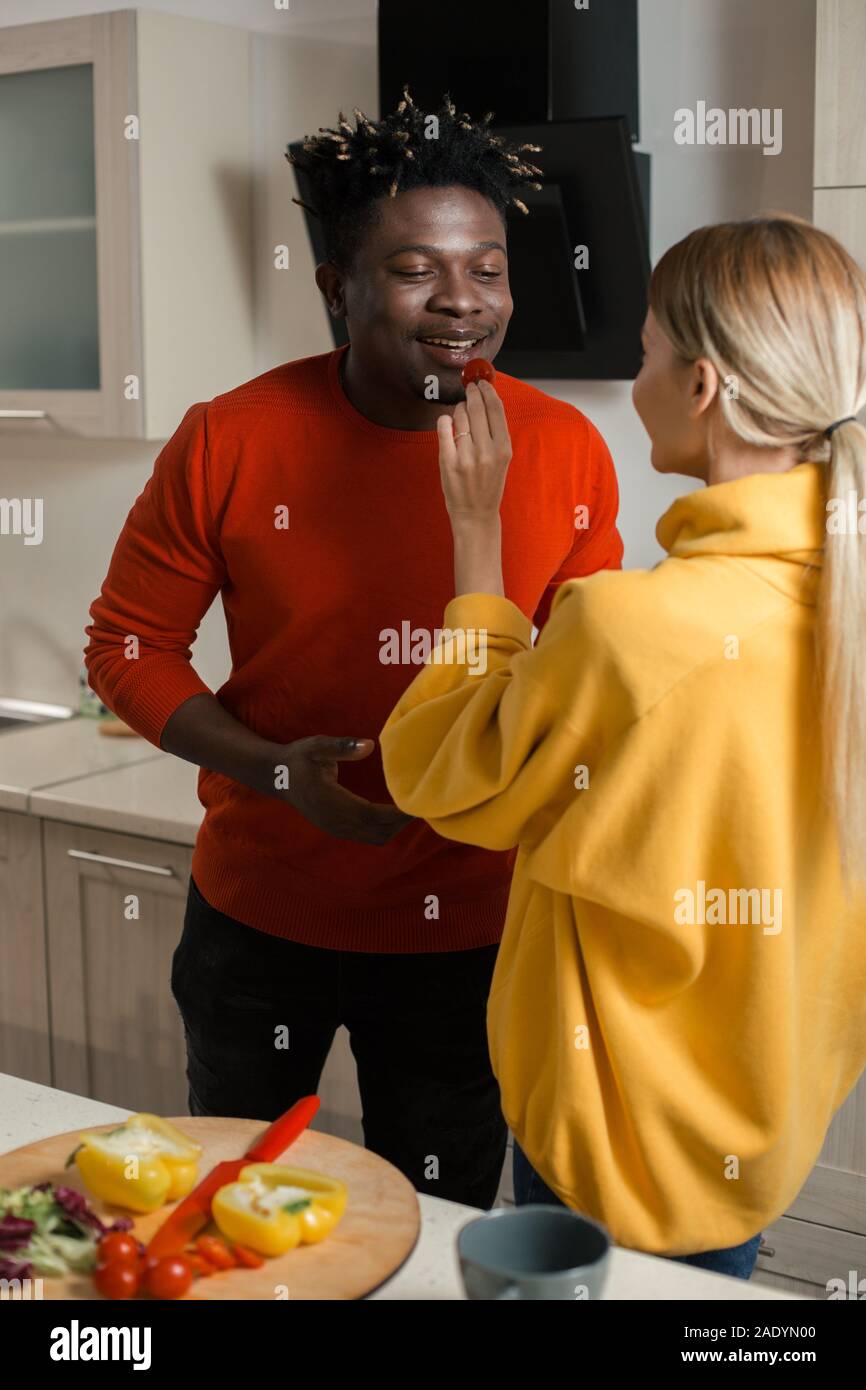 Taille bis der Mann lächelnd und Cherry Tomaten von der Freundin Stockfoto