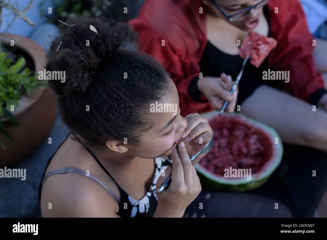 Schwestern essen Wassermelone während einer Hitzewelle in der südafrikanischen Hafenstadt von Kapstadt Stockfoto