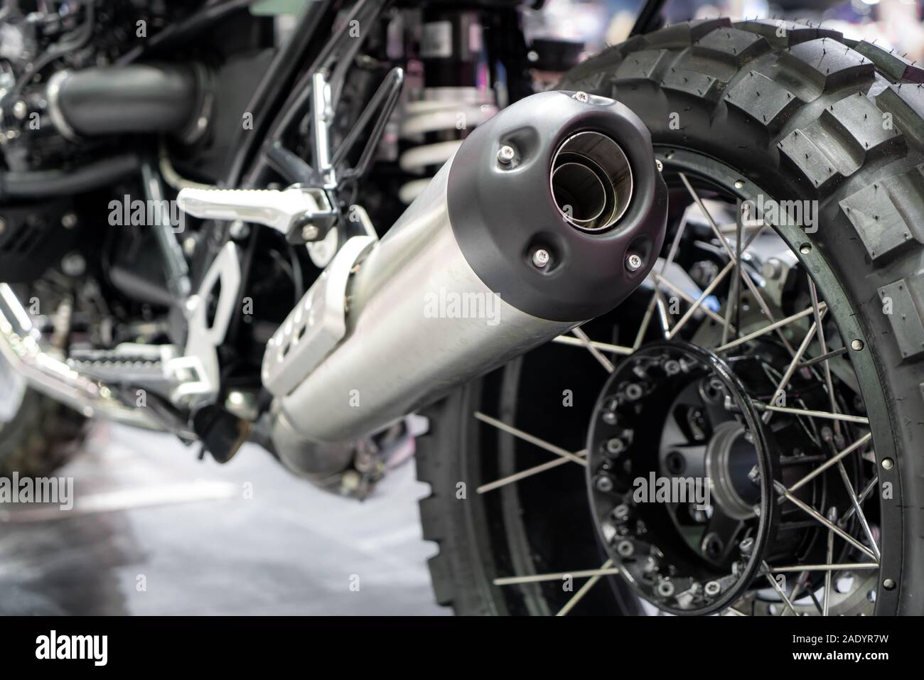 Close-up von Auspuff oder Einnahme von schwarz Sport racing Motorrad mit neuen Reifen und Rad im Showroom. Niedrigen Winkel Foto von Motorrad. Stockfoto
