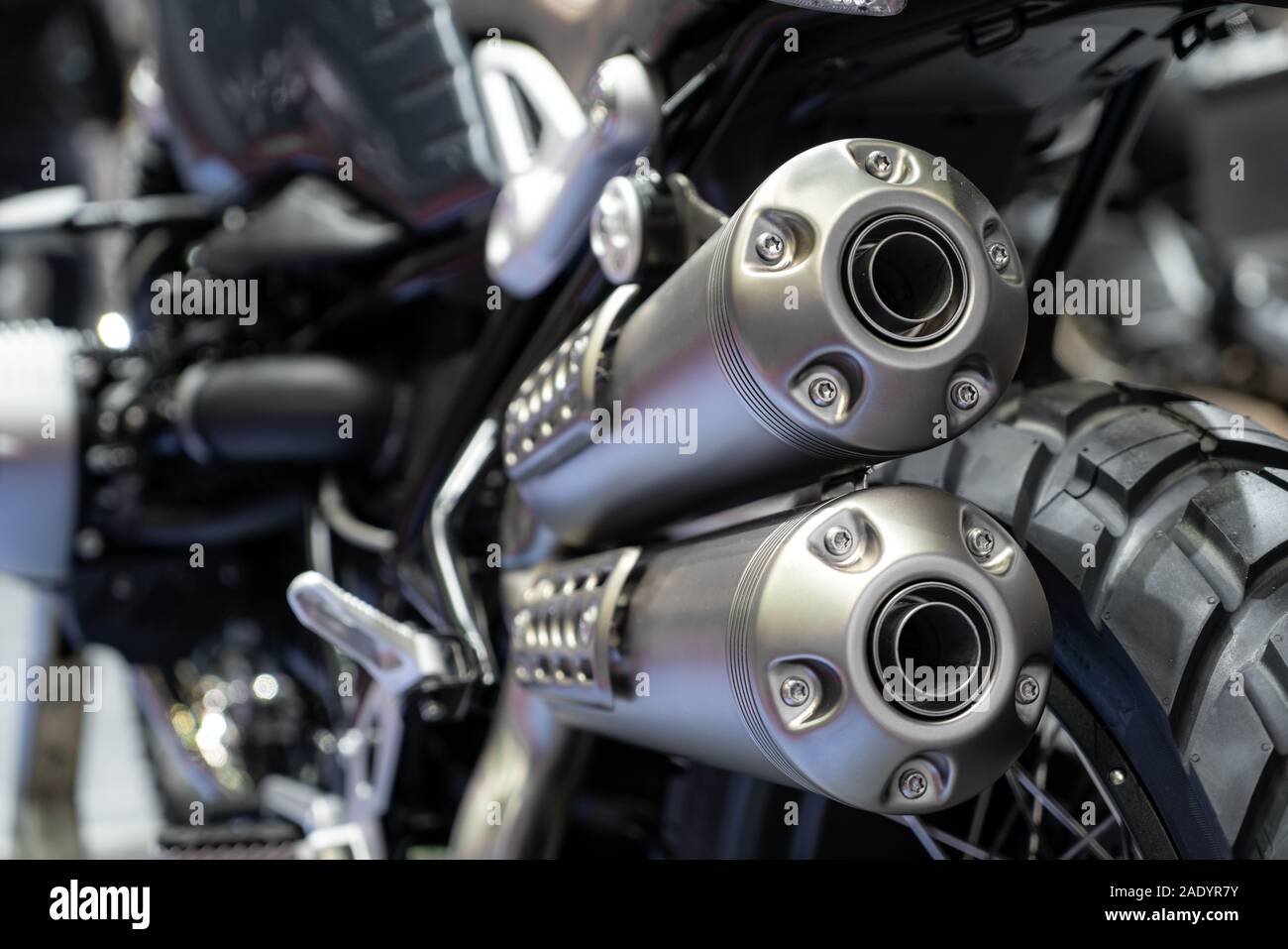 Close-up von Auspuff oder Einnahme von schwarz Sport racing Motorrad mit neuen Reifen und Rad im Showroom. Niedrigen Winkel Foto von Motorrad. Stockfoto