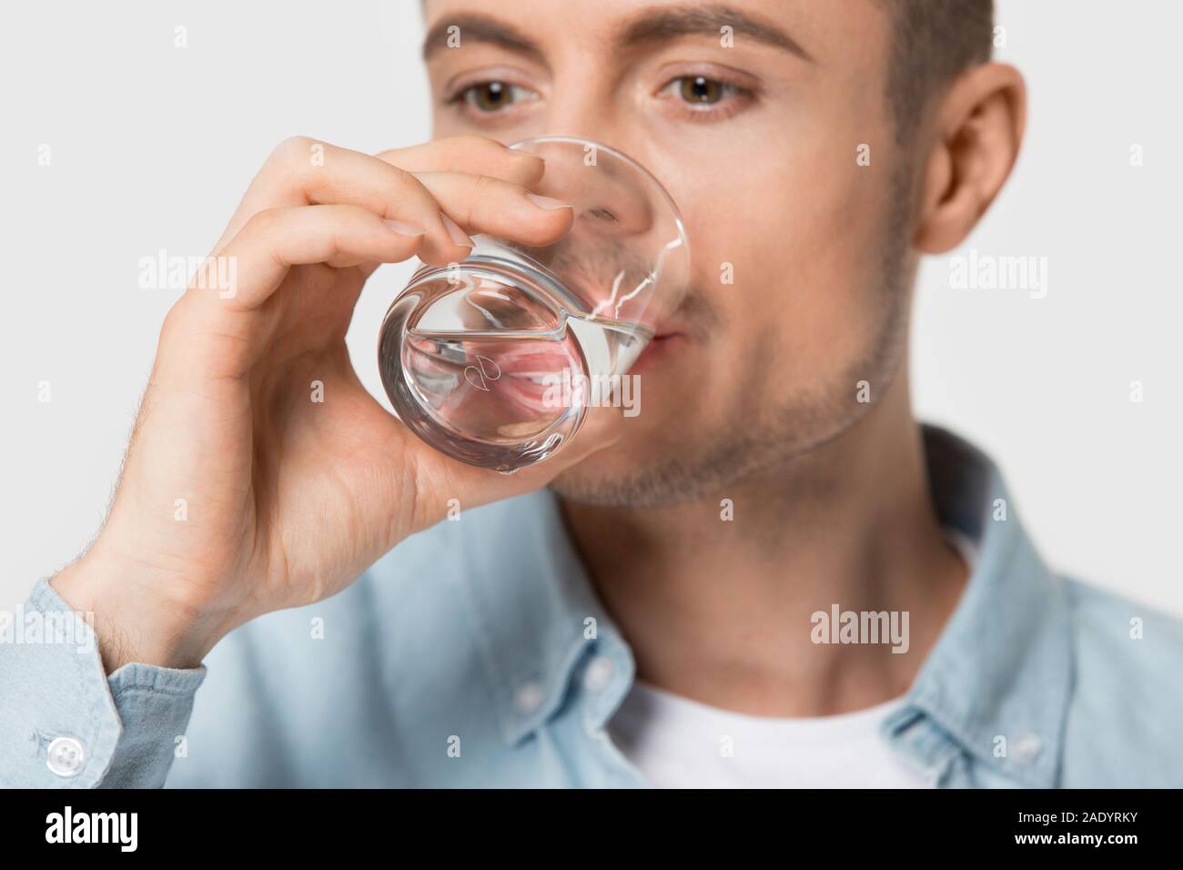 Schließen Sie herauf jungen gesunden Durst Kerl Trinkwasser. Stockfoto