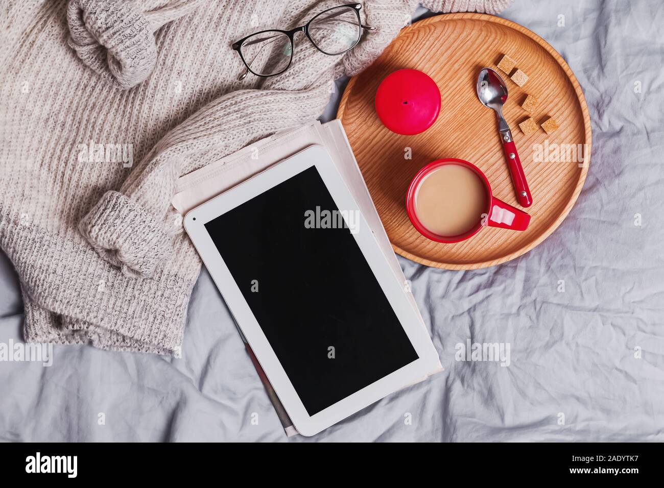 Leere tablet, Tasse Kaffee, gestrickte Pullover und andere kleine Gegenstände Stockfoto